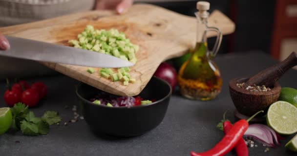 妇女在家庭厨房将切碎的新鲜绿色鳄梨水果倒入黑色陶瓷碗中 Dci — 图库视频影像