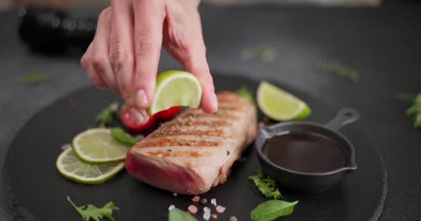 Woman Squeezing Fresh Lime Juice Grilled Tuna Steak Black Stone — Stock Video