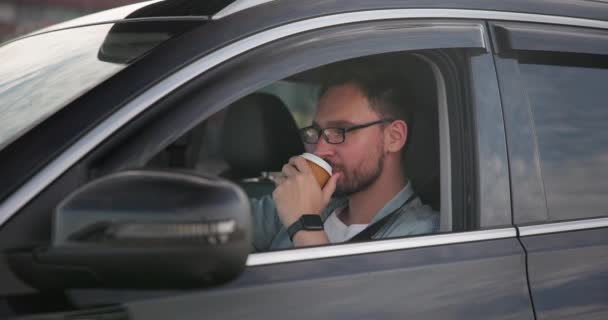 Genç Beyaz Bir Adam Otoparkta Bir Arabada Oturup Kahve Içiyor — Stok video