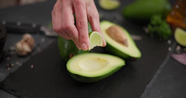 Frau Presst Frischen Limettensaft Auf Grüne Avocadofrüchte Auf Einem Steinernen — Stockvideo
