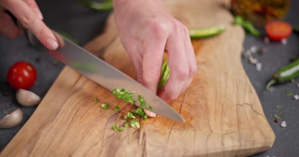 Frau Schneidet Grüne Chilischoten Auf Einem Holzschneidebrett Der Heimischen Küche — Stockvideo
