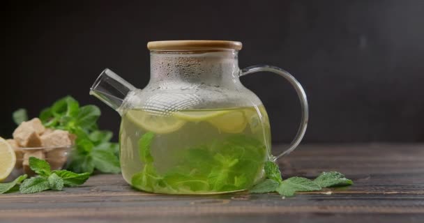 带有柠檬和薄荷的热天然草本植物茶的玻璃茶壶 — 图库视频影像