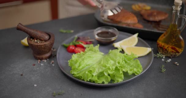 Vrouw Zet Stukjes Gegrilde Biologische Tonijnbiefstuk Een Bord Met Salade — Stockvideo