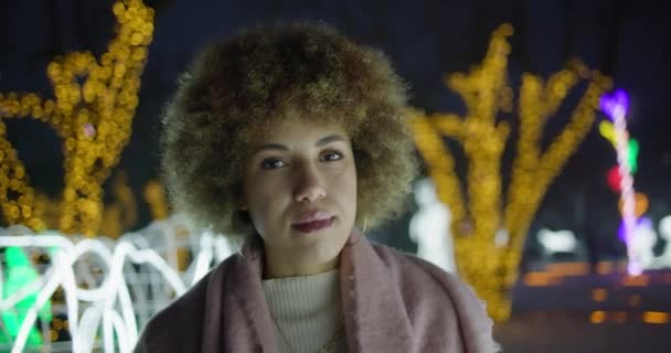 Piękna Afroamerykanka Stojąca Zewnątrz Zimowy Wieczór Tle Girlandy Świateł — Wideo stockowe