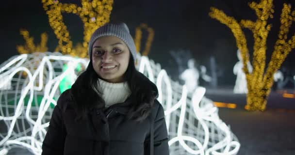 Młoda Hinduska Kobieta Stojąca Zewnątrz Zimowy Wieczór Tle Girlandy Świateł — Wideo stockowe