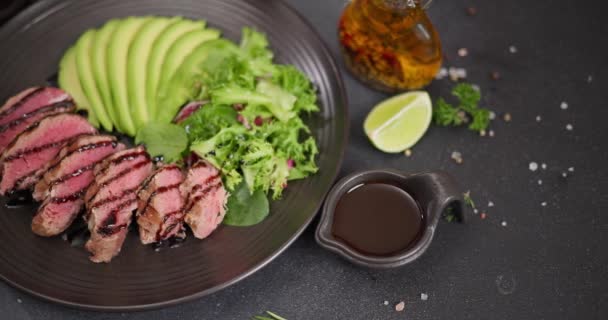 Krájený Grilovaný Tuňákový Steak Nakrájeným Avokádem Černém Kameni Servírovací Tabule — Stock video