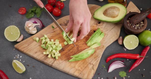 サルサレシピ 女性は 国内のキッチンで木製ボード上の新鮮な緑のアボカドフルーツを切断します Dciについて — ストック動画
