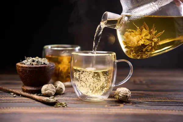 Чай Наливают Чашку Стекла Чайник Цветущий Цветок Чая Внутри Деревянный — стоковое фото