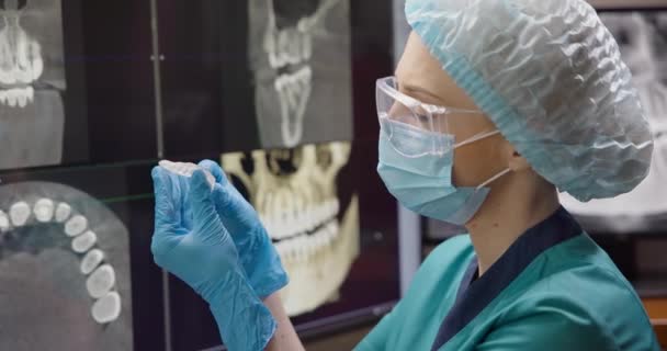 整形歯科医は X線背景にナイトブルキズム保護筋肉リラックスした口ガードを保持しています Dciについて — ストック動画