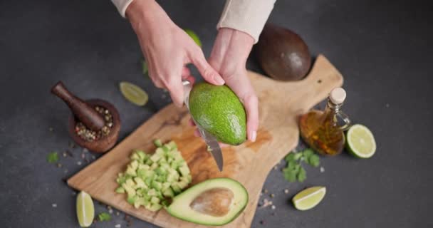 女人把新鲜的绿色鳄梨水果切成两半 Dci — 图库视频影像