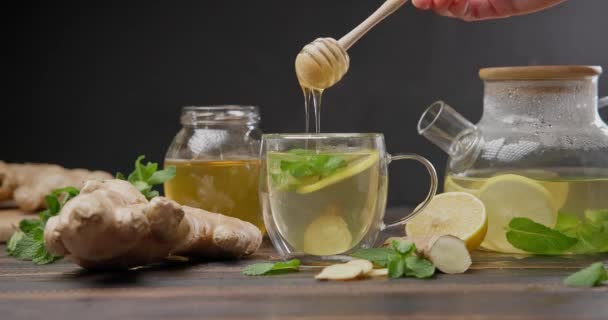 女人用勺子柠檬和姜热蒸有机草茶在玻璃杯中拌匀 — 图库视频影像