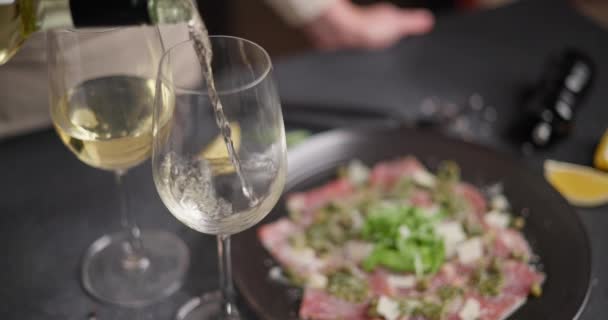 Mulher Derrama Vitória Branca Vidro Para Complementar Jantar Com Carpaccio — Vídeo de Stock