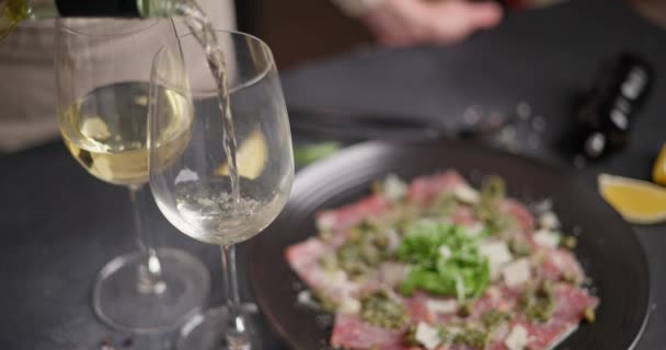 Mulher Derrama Vitória Branca Vidro Para Complementar Jantar Com Carpaccio — Vídeo de Stock