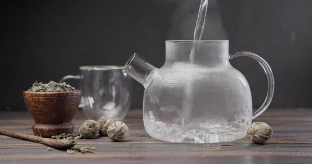 Varmkokande Vatten Häller Glas Tekanna Med Blommande Blomma Trä Bakgrund — Stockvideo