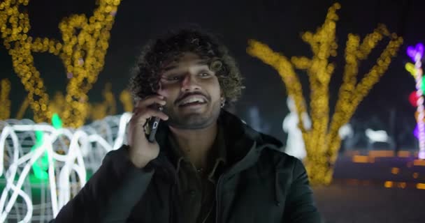 Ung Indisk Man Talar Telefonen Stående Utomhus Vintern Kväll Girlanger — Stockvideo
