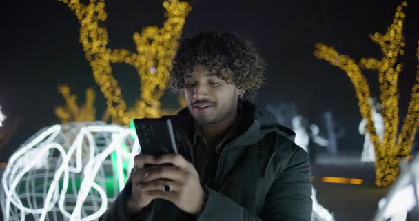 Homem Indiano Jovem Digitando Mensagem Telefone Livre Noite Inverno Guirlandas — Vídeo de Stock