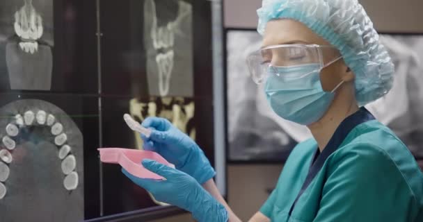 整形外科歯科医は X線背景の箱にナイトブルキズム保護筋肉リラックスした口のガードを置きます Dciについて — ストック動画