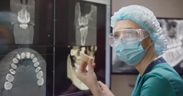 Ortopedik Dişçi Röntgen Arka Planında Hastaların Çenelerinin Diş Izlerini Tutuyor — Stok video