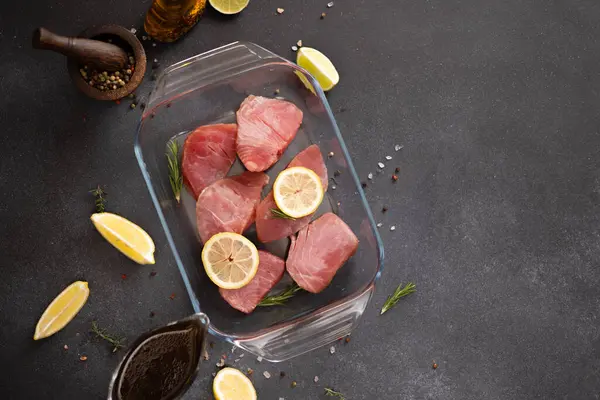 用玻璃器皿烹调的鱼片和肉汤酱汁腌制的新鲜金枪鱼片 — 图库照片