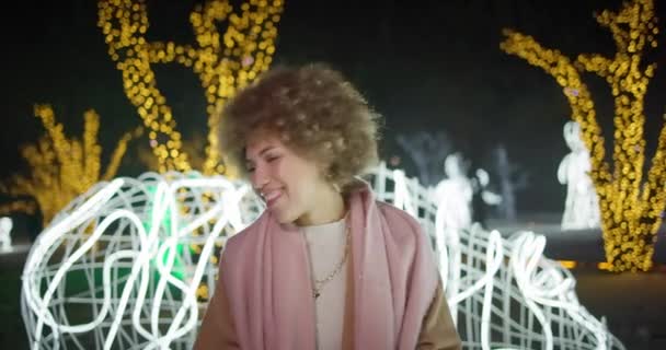 年轻的非洲裔美国妇女在户外的花环和灯光背景下跳舞和玩乐 新年假期 — 图库视频影像