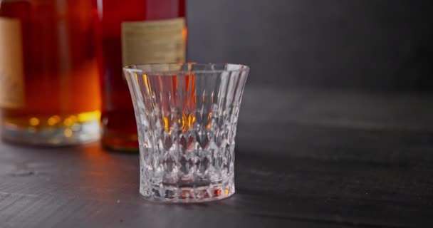 Barmen Şişelerin Arka Planında Cam Viski Bardağına Soğutmak Için Buz — Stok video