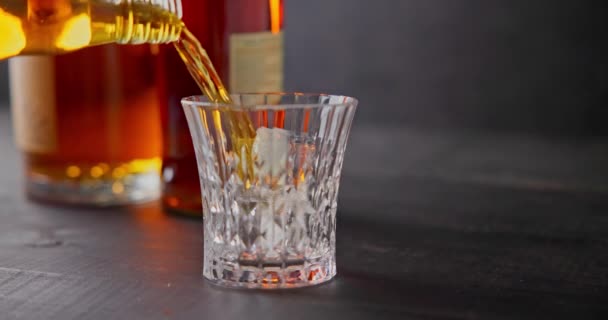 Barman Nalévá Whisky Sklenice Kostkami Ledu Pro Chlazení Pozadí Lahví — Stock video