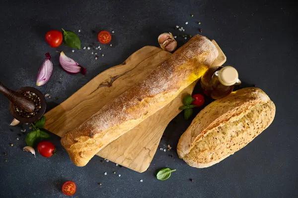 Freshly Baked Bread Wooden Cutting Board Dark Table lizenzfreie Stockfotos