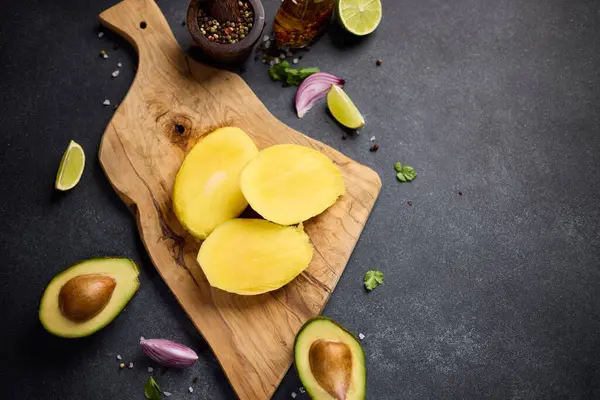 Aufgeschnittene Mango Auf Einem Holzschneidebrett Der Heimischen Küche lizenzfreie Stockfotos