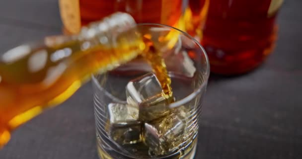 Barman Wlewa Whisky Szklanki Zimnym Żelazem Chłodzenia Tle Butelek Nagranie — Wideo stockowe