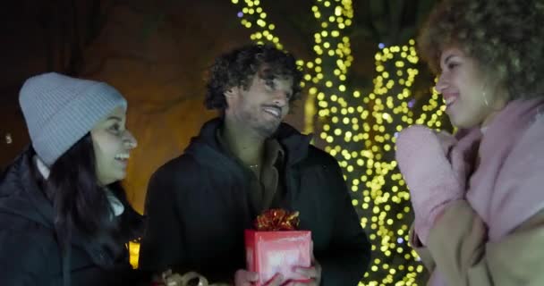 年轻的印度男子以彩灯和花环为背景 以新年和圣诞为主题 送给女人一份礼物 — 图库视频影像