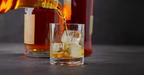 Bartendern Häller Whisky Glas Med Isbitar För Kylning Bakgrund Flaskor — Stockvideo