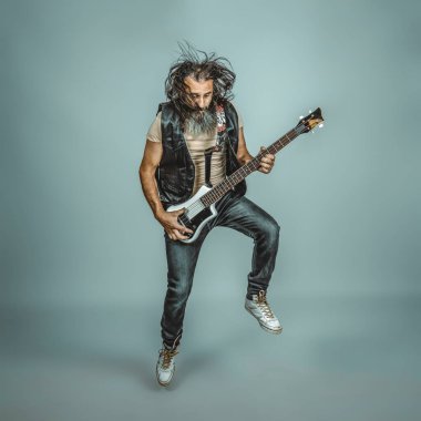 Bas çalan uzun saçlı ve sakallı bir müzisyen.