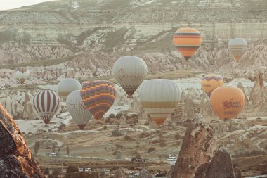 GOREME / TURKEY - 27 Haziran 2022: Sıcak hava balonları gün doğumunda Goreme şehrinin üzerinde uçuyor