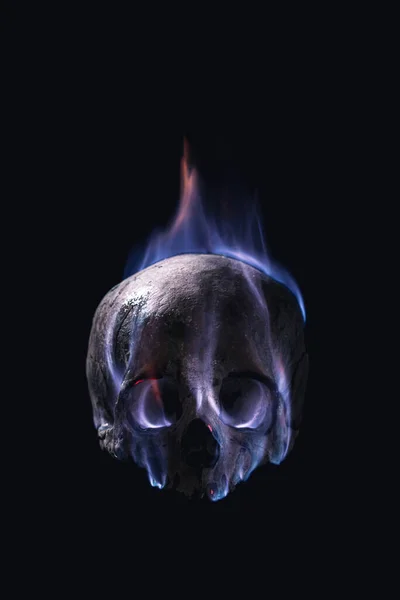 黒い背景の炎の中の人間の頭蓋骨は — ストック写真