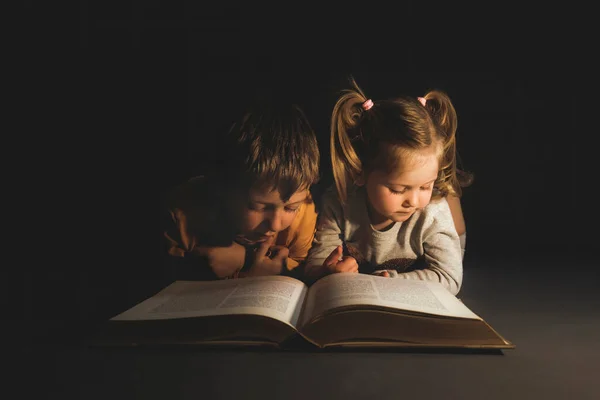 Children Lying Dark Reading Book — Stock Photo, Image
