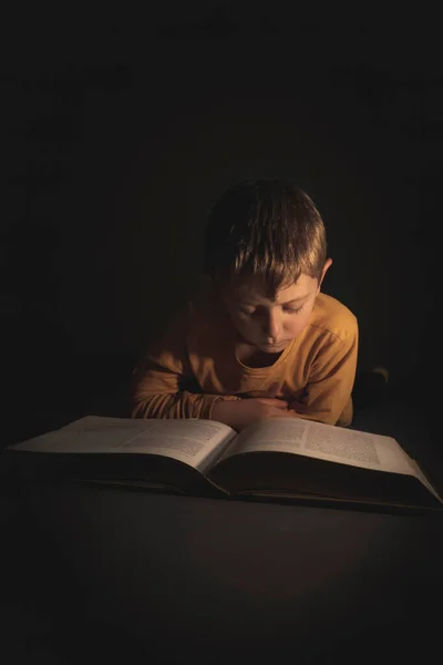 Kind Leest Een Boek Liggend Duisternis Zich Heen — Stockfoto