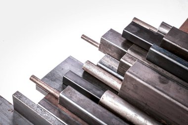 beyaz arkaplanda farklı bölümlere sahip tübüler metal profilleri