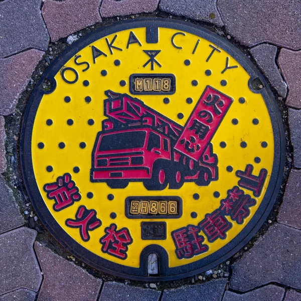 大阪有色消防车的井盖 — 图库照片