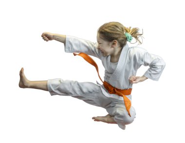 Karate üniformalı enerjik genç kız yüksek tekme atıyor.