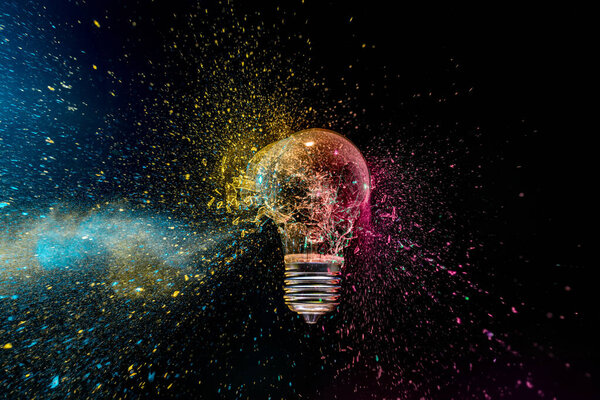 colorful exploding lightbulb powder splash  dark background 