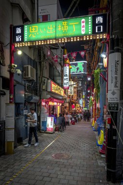 Shinjuku, Tokyo 'daki omoide yokocho sokağı gece aydınlatma işaretleriyle dolu., 
