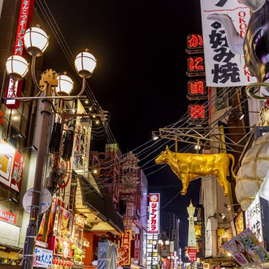 Altın inek heykeli işlek bir Osaka caddesinde asılı, Japonya