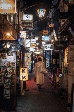 Shinjuku 'da gece sokakta yürüyen bir kadın.