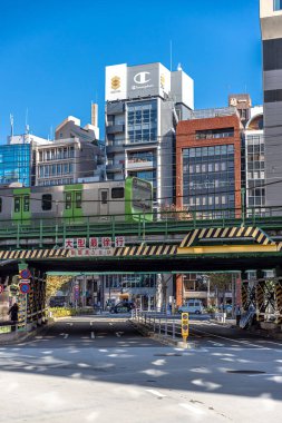 Şehir caddesinden geçen banliyö treni Japonya Tokyo 'da.