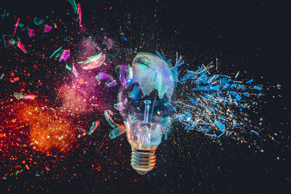 Lightbulb exploding colorful burst powder  glass black background