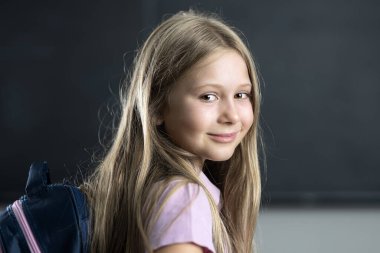 Sırt çantası takan gülümseyen beyaz kız.