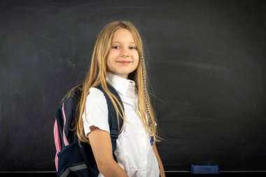 Okul konseptine geri dönelim, gülümseyen okul kızı tebeşir tahtası