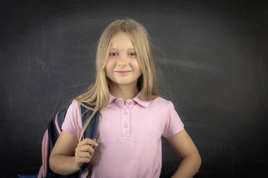 Sırt çantası taşıyan gülümseyen ilkokul öğrencisi