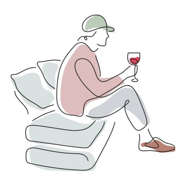 Kanepede oturmuş kırmızı şarap içen biri.