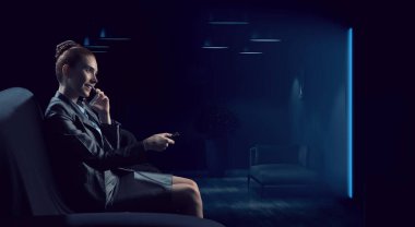 Sinemada film izleyen genç bir kadın. Karışık ortam